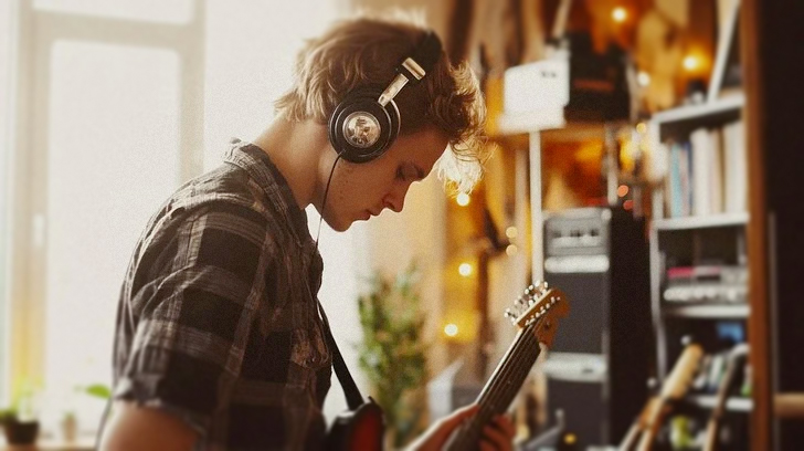 Young adult practicing on guitar